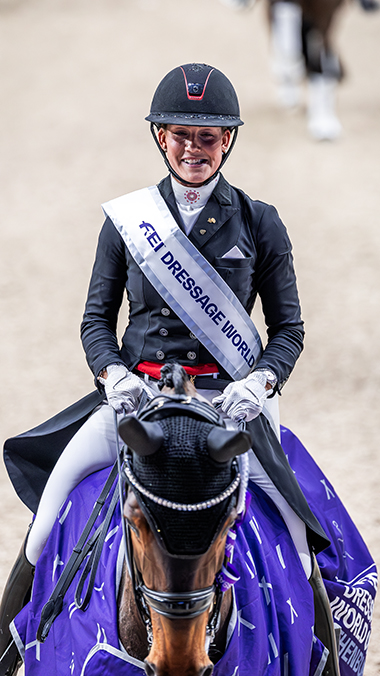 Dressyrryttare glad under prisutdelning.