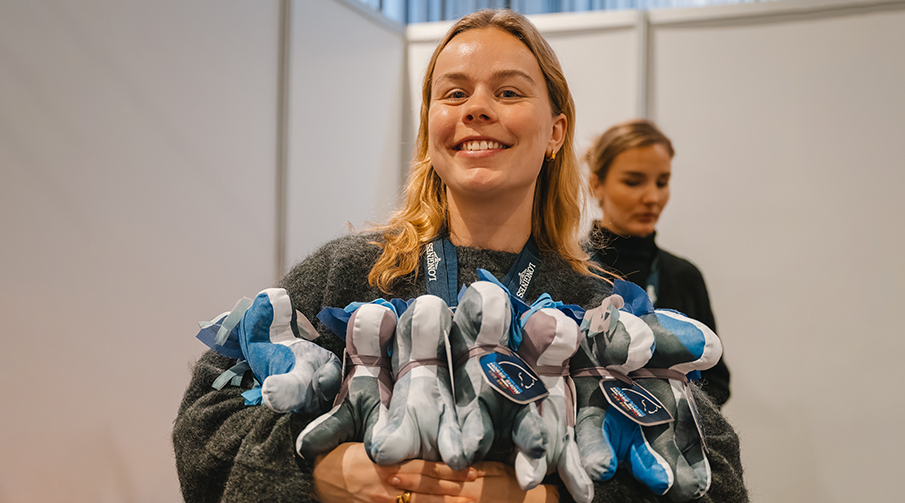 Glad tjej med flera gosedjurshästar i famnen. 