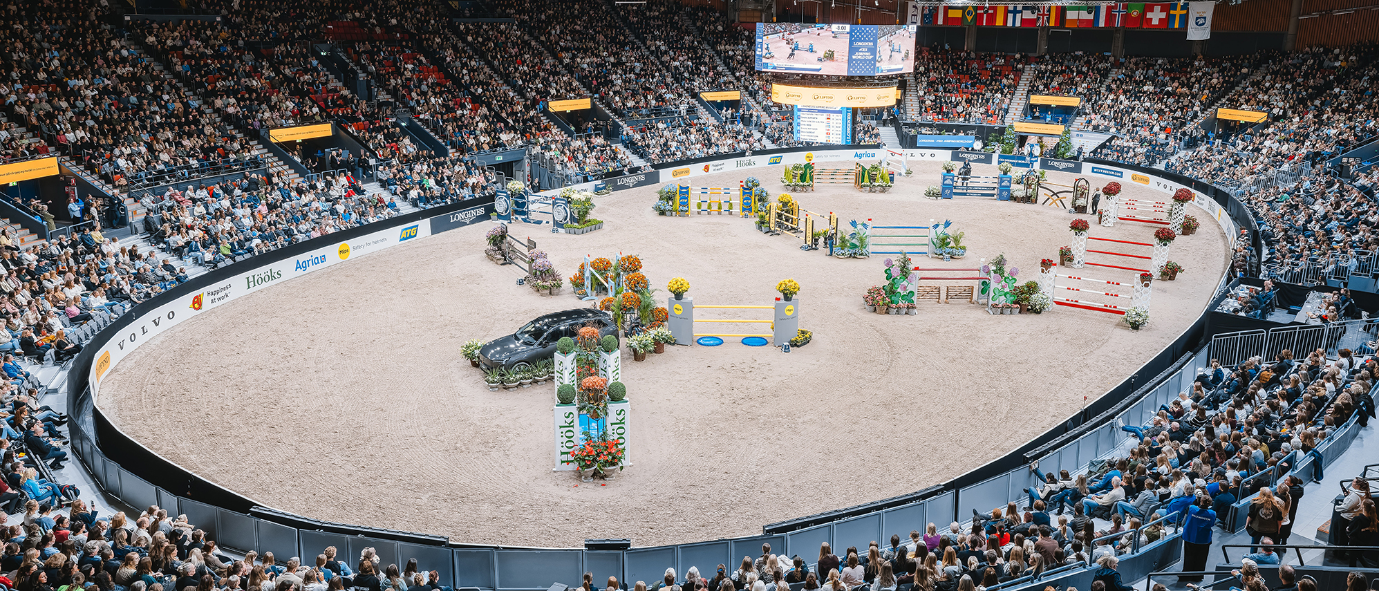 Bild över arenan som är fullsatt med hinder och en bil parkerad. 